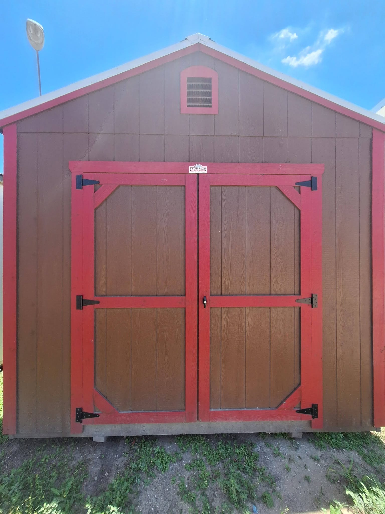 Utility shed with double doors and red trim built by Stor-Mor
