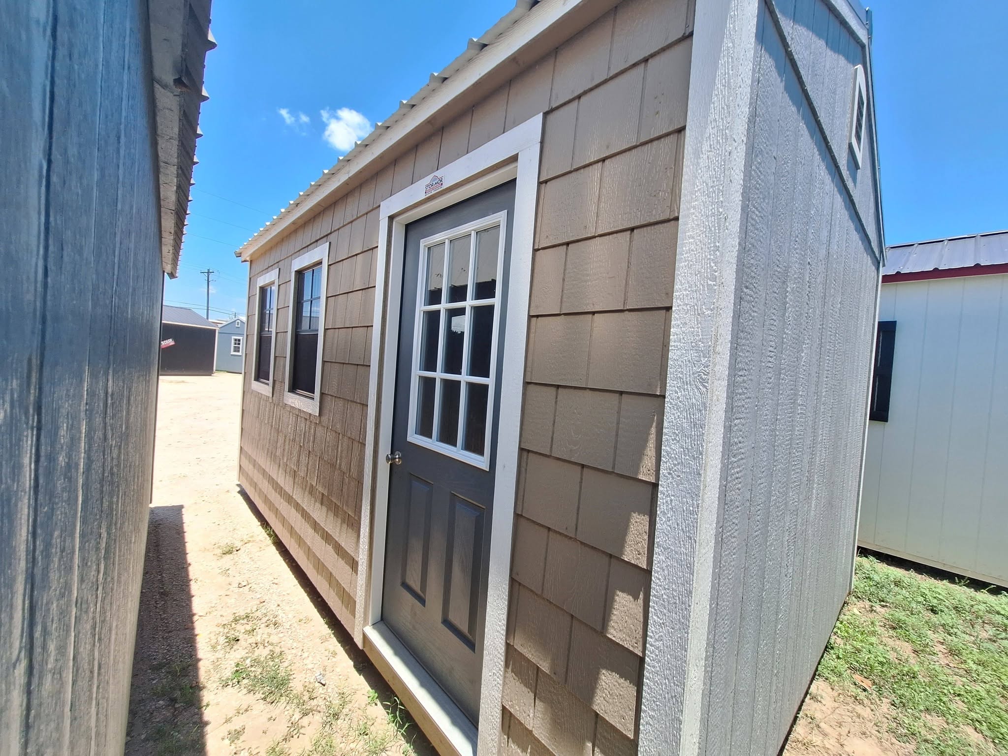 Portable cabin with shake siding and a glass-panel door in the Rio Grande Valley